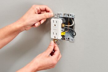 Electrician installing and wiring a GFCI outlet for safety compliance — Surge Electrical, King County WA