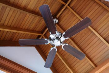 Ceiling fan installed on a wood-paneled ceiling in a residential home
